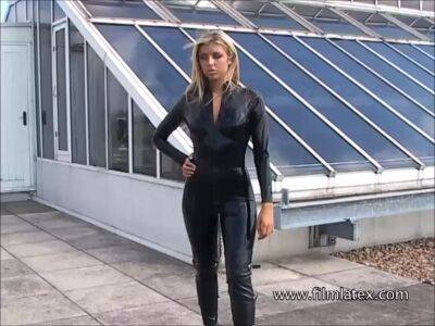 Blonde latex-babes outdoor knee boots and high heels of fetish girl in tight full body rubber outfit with softcore glamour model Karina outside on the roof on femdomerotic.com