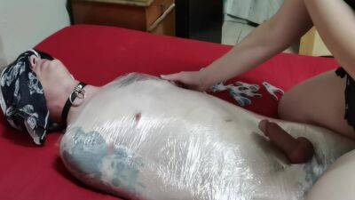 Mistress Wraps Her Slave In Clingwrap on femdomerotic.com