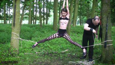 Submissive teen tied up in the woods on femdomerotic.com